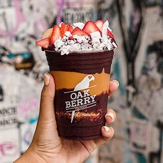 A hand holding an OAKBERRY Bowl