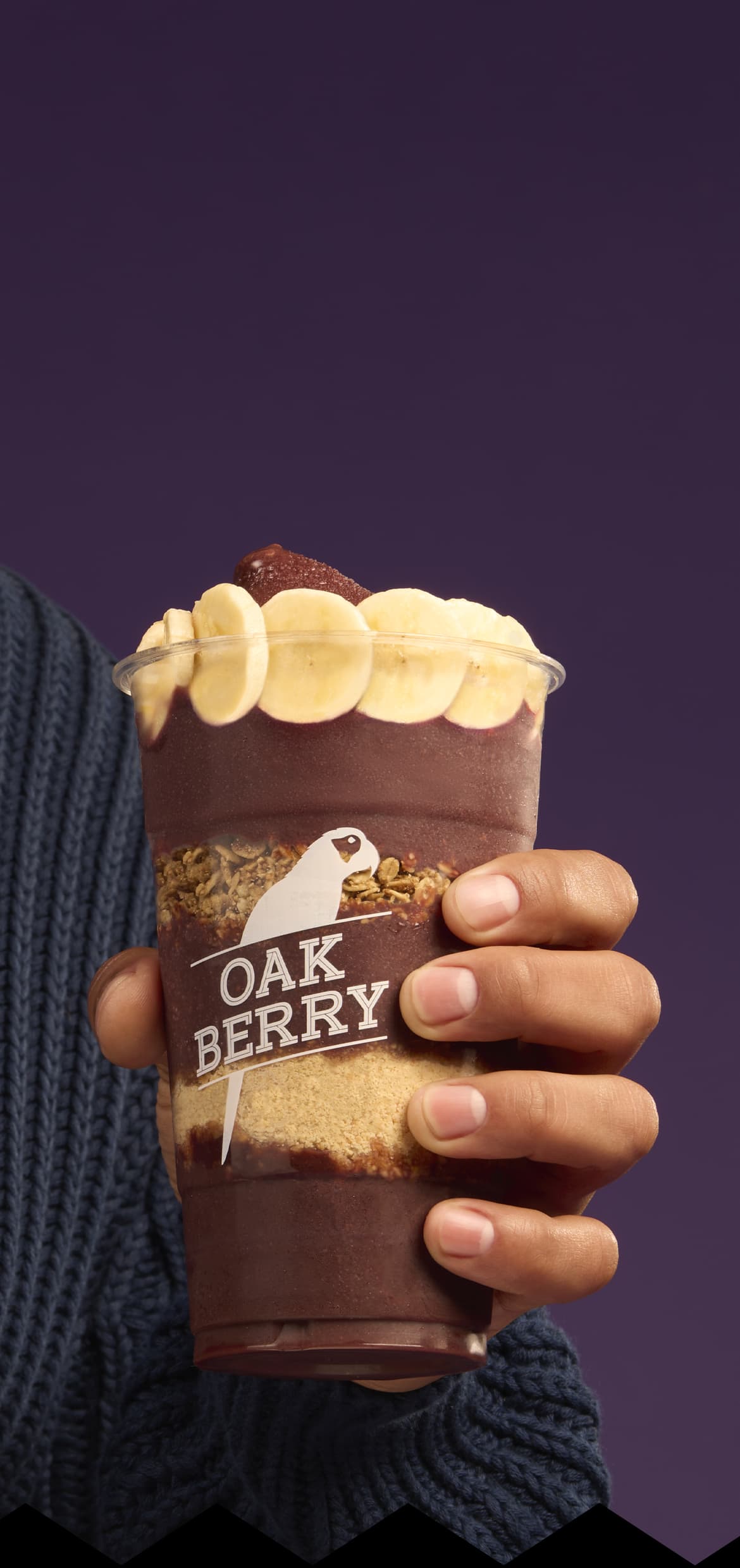 A hand holding an OAKBERRY bowl