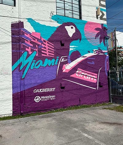 A mural of a race car and OAKBERRY's Logo a building